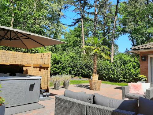 a patio with a couch and an outdoor grill at Secret Wellness Boszicht in Holten