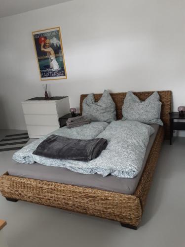 uma cama de vime com um cobertor e almofadas em Appartement im Hasental em Garmisch-Partenkirchen