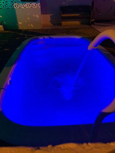 a blue swimming pool in a dark room at Casa cinza em frente à praia em condominio in Aracaju