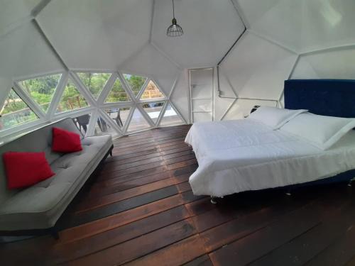 a bedroom with a bed and a couch in a room at Caba-glamping La Fortuna de Luna in Villa de Leyva