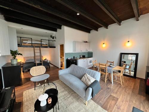 a living room with a couch and a dining room at Bed & Breakfast Heit in Joure