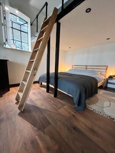 Dormitorio tipo loft con cama y escalera en Authentieke studio in hartje Joure en Joure