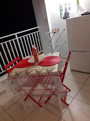 une chaise rouge et une table dans la cuisine dans l'établissement STUDIO VUE SUR MER, à Le Moule