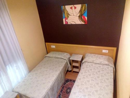 Zimmer mit 2 Betten und Wandgemälde in der Unterkunft ALBOR II in Gijón