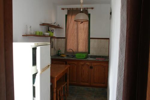 a kitchen with a refrigerator, stove, microwave and a sink at La Palma Hostel by Pension Central in Fuencaliente de la Palma