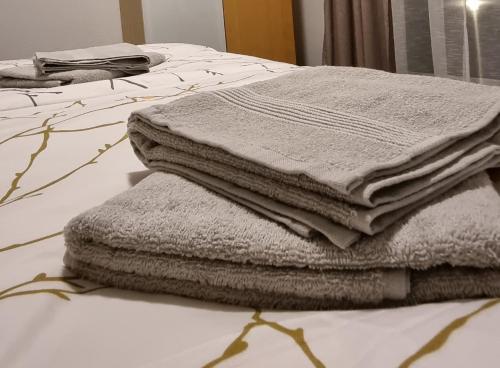una pila de toallas sentadas encima de una cama en Flat11 4-Zi Wohnung Messe Karlsruhe en Rheinstetten
