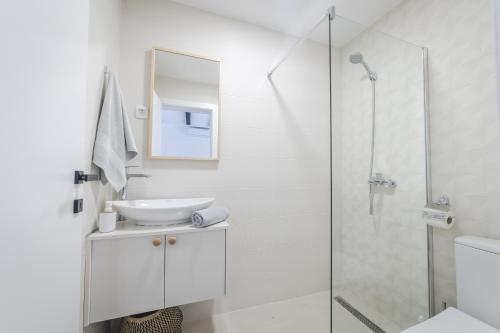 a white bathroom with a sink and a shower at Kami The Essence in Danilovgrad