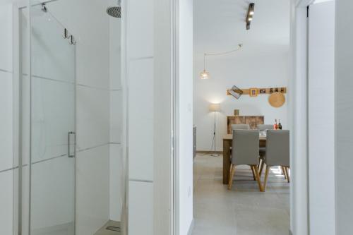 a kitchen and dining room with white walls and glass doors at Ivino in Omiš