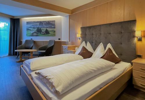 a bedroom with two beds in a hotel room at Hotel Condor in Selva di Val Gardena