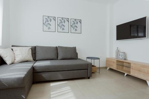uma sala de estar com um sofá e uma televisão em Ivino em Omiš