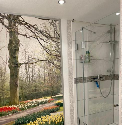 a shower with a view of a garden with tulips at Ferienwohnung Inga in Spabrücken
