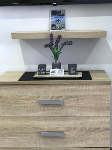 a dresser with two cups and a plant on it at Aphrodite Hills Apartments-Stara Planina in Crni Vrh