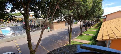 a view of a street with a pool and trees at diRoma Fiori - Apartamentos JN in Caldas Novas