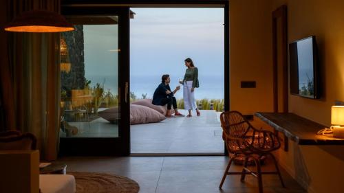 Due donne in piedi in un soggiorno con specchio di Lithi Luxury Retreat a Imerovigli