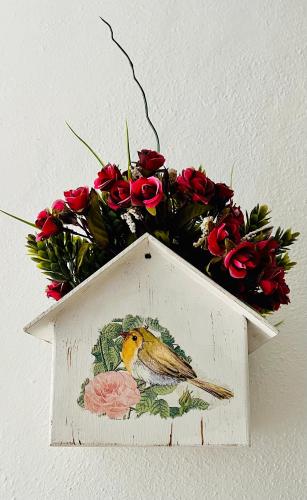 a bird house with flowers on top of it at Casa Cardennal in San Miguel de Allende