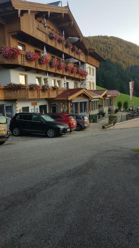 a large building with cars parked in a parking lot at Gasthof Schöntal in Oberau
