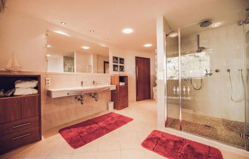 a bathroom with a shower and a sink at Superior Sport und Familienresort Alpenblick in Zell am See