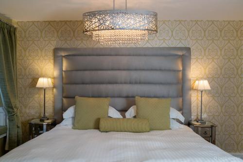 a bedroom with a large white bed with two pillows at Grassington House in Grassington