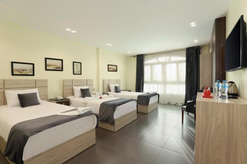 a hotel room with two beds and a television at Brothers Pyramids View in Cairo
