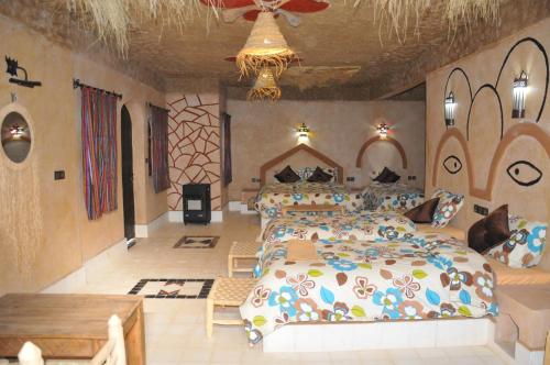 a large bedroom with two beds and a table at Maison Acacias in Erfoud