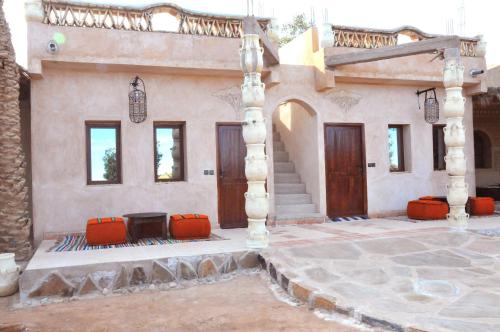 a house with orange chairs and a building at Maison Acacias in Erfoud