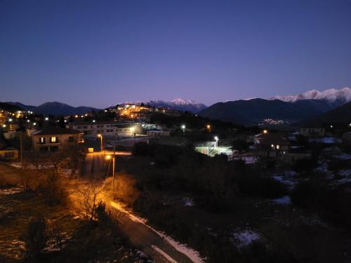 a city at night with mountains in the background at Xenonas Epavli in Levidhion