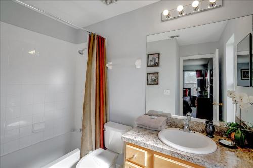 een badkamer met een wastafel, een toilet en een spiegel bij EXCELLENT 7 Bedroom EIR Vacation Villa - PRIVATE POOL in Kissimmee
