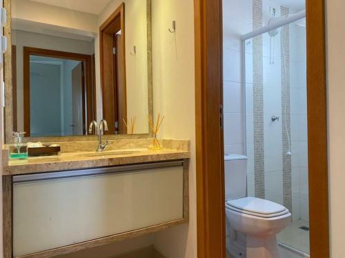 uma casa de banho com um lavatório, um WC e um espelho. em Sunset em Ponta Grossa
