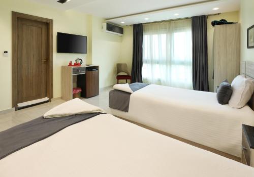a hotel room with two beds and a television at Brothers Pyramids View in Cairo