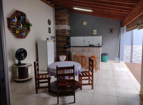 una cucina e una sala da pranzo con tavolo e sedie di Recanto Caldeira a Olímpia