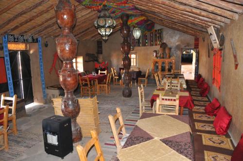a dining room with wooden tables and chairs at Maison Acacias in Erfoud
