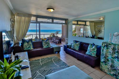 a living room with couches and a view of the ocean at Sands Beach Breaks Beach Front Ballito in Ballito