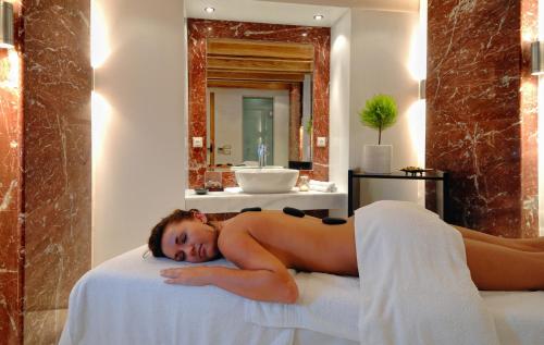 a naked woman laying on a bed in a bathroom at Blue Sea Beach Affiliated By Melia in Stalida