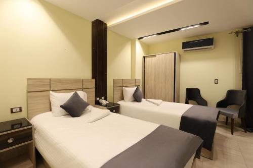 a hotel room with two beds and a desk at Brothers Pyramids View in Cairo