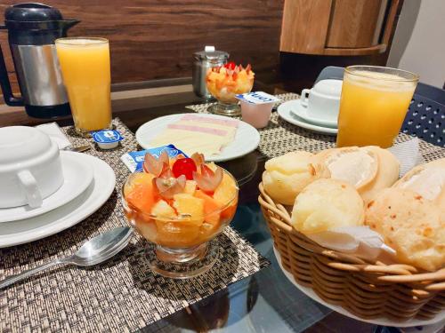 a table topped with plates and glasses of orange juice at Motel Caribe in Belo Horizonte
