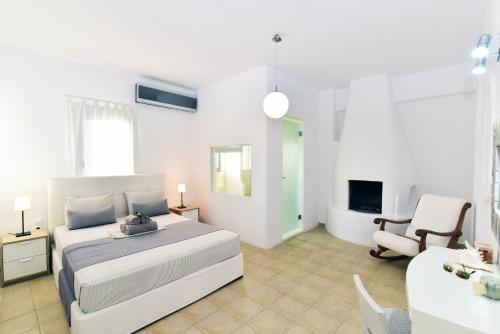 een witte slaapkamer met een bed en een stoel bij Thomas Apartments Katapola - Chora in Katápola