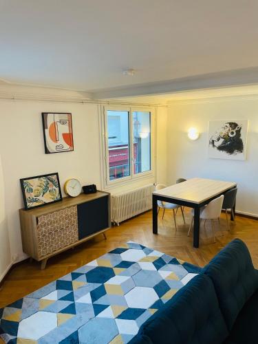 un salon avec une table et un canapé dans l'établissement Charmant appartement de cœur de ville - 2 chambres lits Queen size - NETFLIX - WIFI, à Cherbourg en Cotentin
