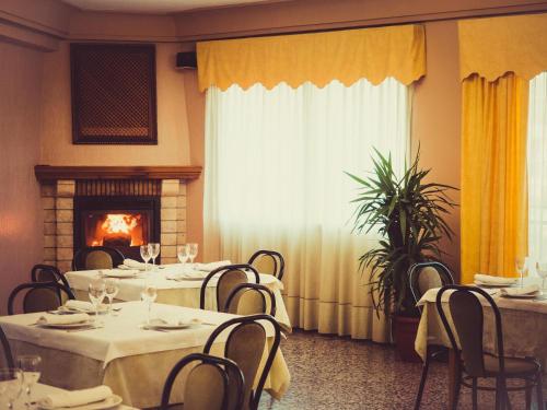a dining room with tables and chairs and a fireplace at HOTEL MORENO in Elche de la Sierra