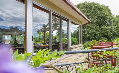 a house with windows and a patio with tables and chairs at Leura Gardens Resort in Leura