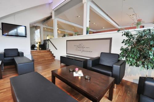a waiting room with black chairs and a table at Hotel Bodensee-Arena in Kreuzlingen