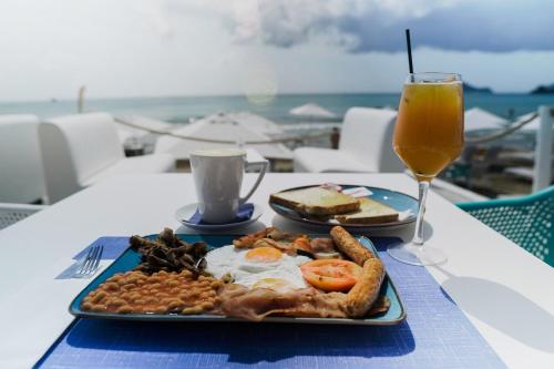 a plate of breakfast food and a glass of orange juice at Sea Shell Beach Suite in Laganas