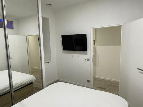 sypialnia z telewizorem na ścianie i łóżkiem w obiekcie Gallo Superior w Nicei