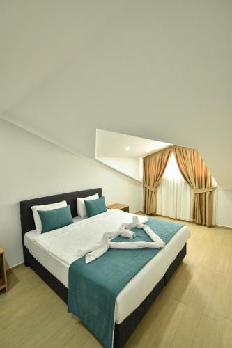 a bedroom with a large bed with blue pillows at Çetkin Exclusive Apart in Fethiye