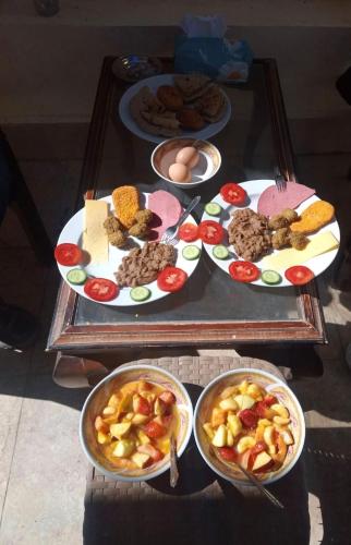 a table with plates of food and bowls of food at Go Inn Backpackers in Aswan
