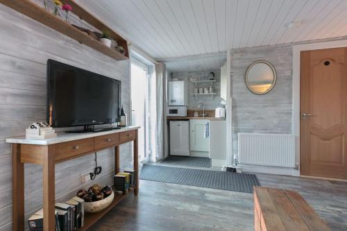 a living room with a television on a wooden table at Loughview chalet in Whitehouse Lower