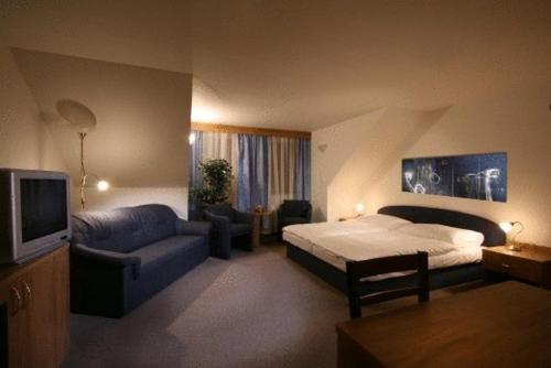 a hotel room with a bed and a couch at Kastiel Lucivna in Lučivná