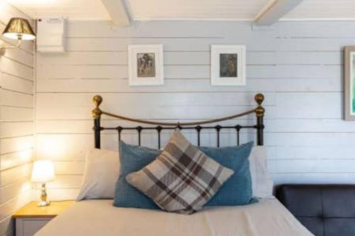 a bedroom with a bed with blue pillows at Loughview chalet in Whitehouse Lower