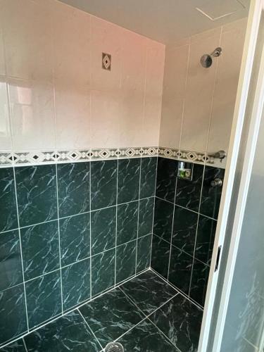 a green tiled shower with a green tile floor at Hotel El Senador in Mexico City