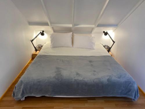 a bedroom with a large bed with two lamps at French Andes Apart Hostel in Pucón