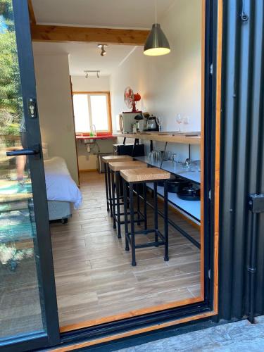 a room with a kitchen with a table in it at French Andes Apart Hostel in Pucón